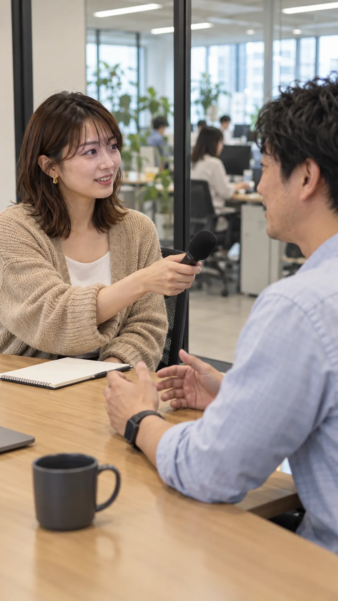 オフィスで社員に取材するタレント（撮影イメージ）